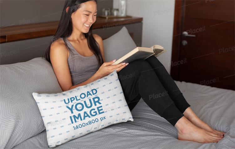Placeit Pillow Mockup Of A Smiling Woman Reading In Bed